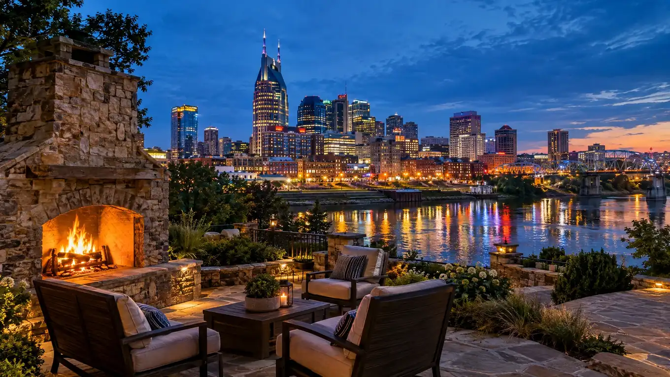 Nashville skyline across the Cumberland River at blue hour seen from a stone patio with an outdoor fireplace