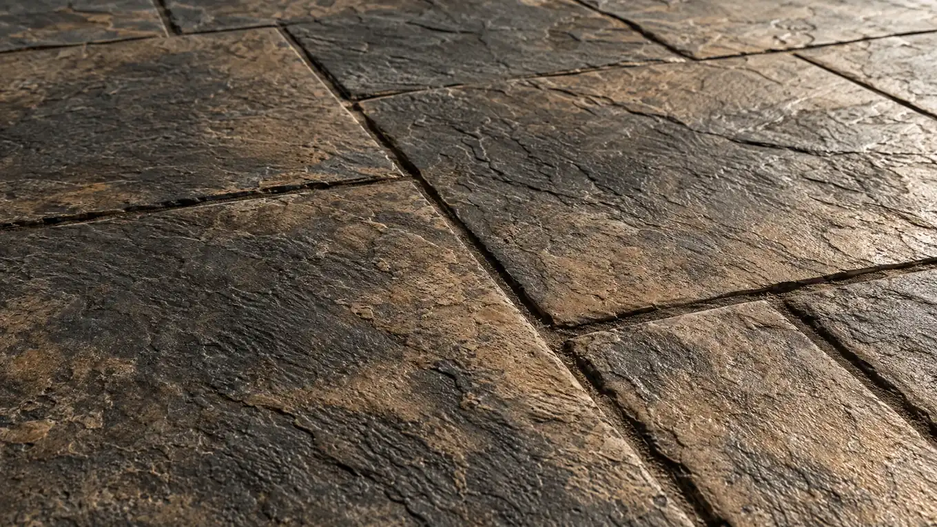 Close-up of stamped concrete in an ashlar slate pattern with a warm charcoal and tan antique finish